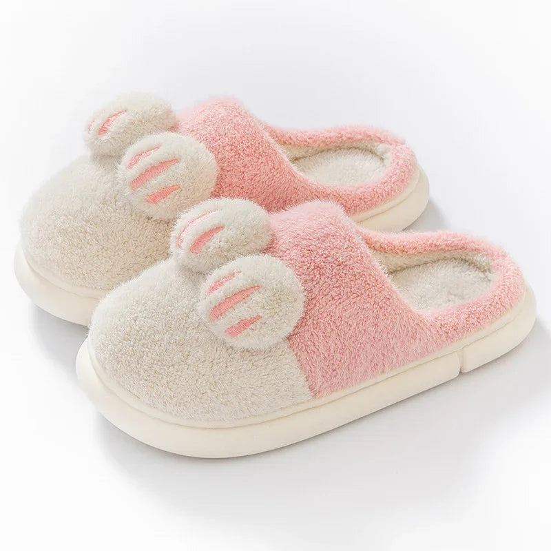 Cozy pink and white fuzzy slippers with bunny ear accents and soft cushioned soles