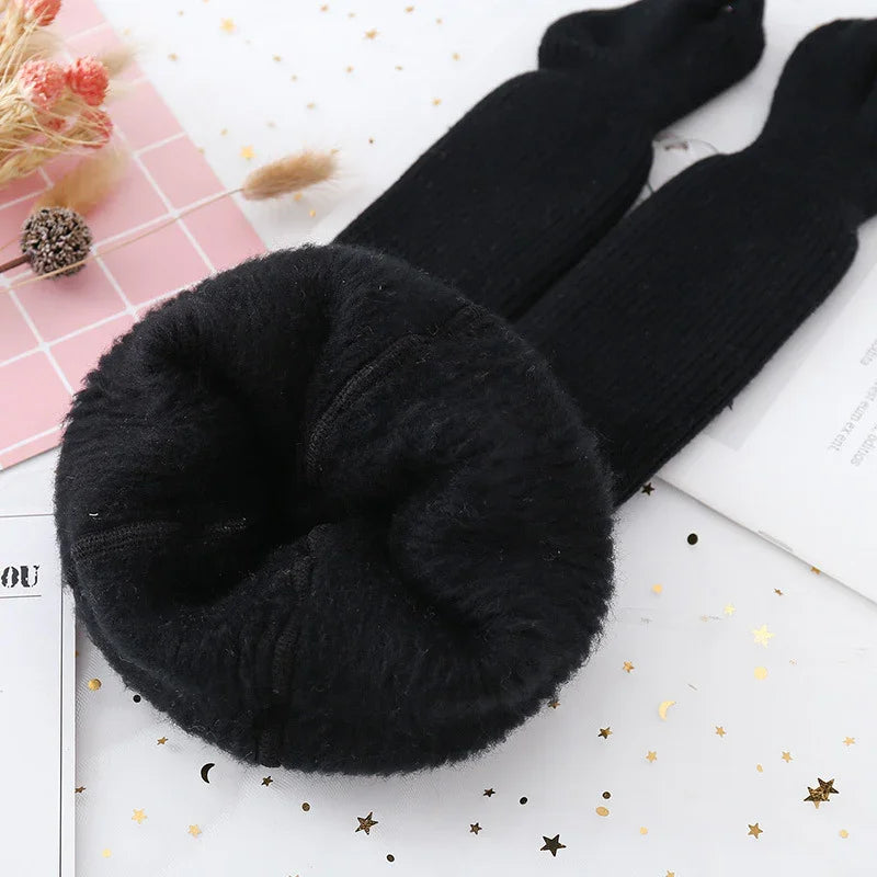 Black fuzzy winter leggings with soft lining on festive star-patterned white surface