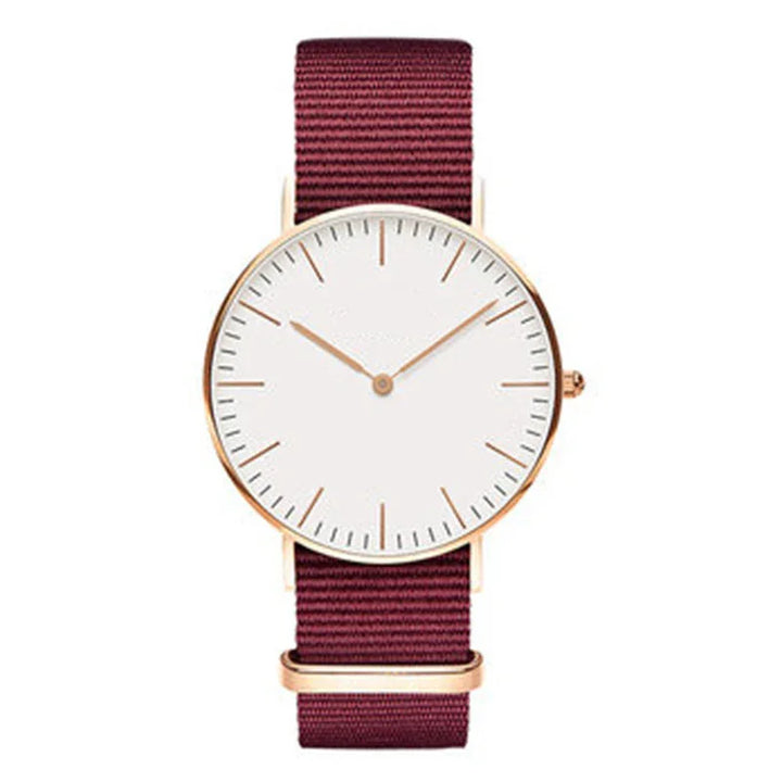 Minimalist wristwatch with rose gold case, white dial, and maroon fabric strap