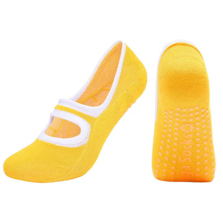 Yellow grip socks with white trim and non-slip dots on the sole, designed for yoga or pilates