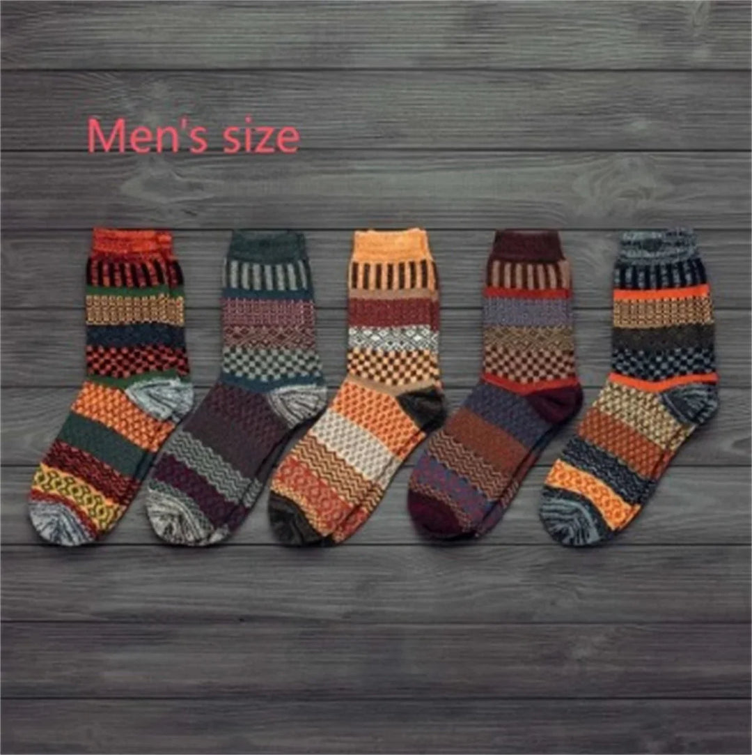 Set of five men's colorful patterned wool socks arranged on a gray wooden floor