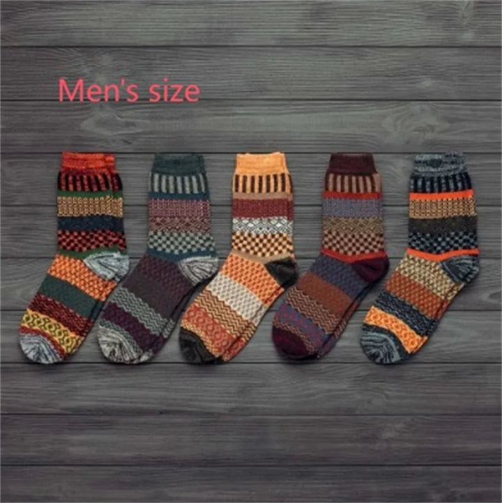 Set of five men's colorful patterned wool socks arranged on a gray wooden floor