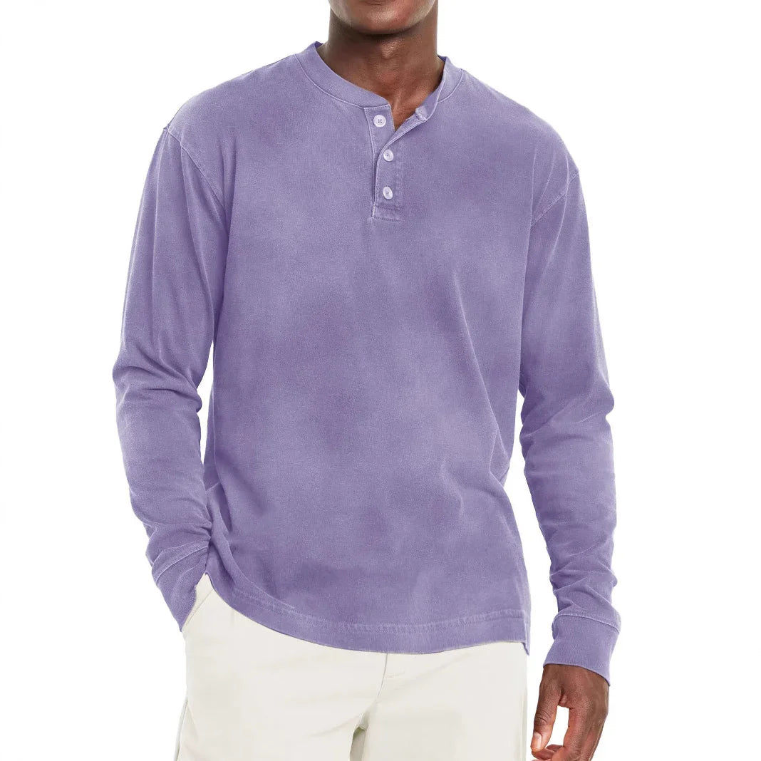 Man wearing a long sleeve lavender henley shirt with three buttons and beige pants