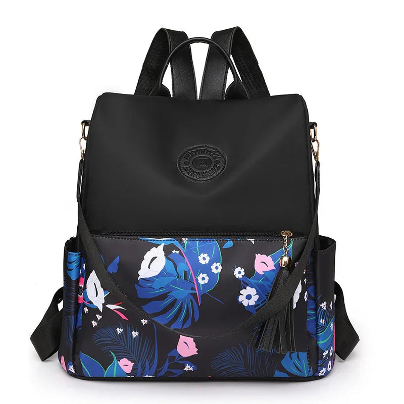 Black backpack with blue and pink floral print, front zipper pocket, and shoulder straps