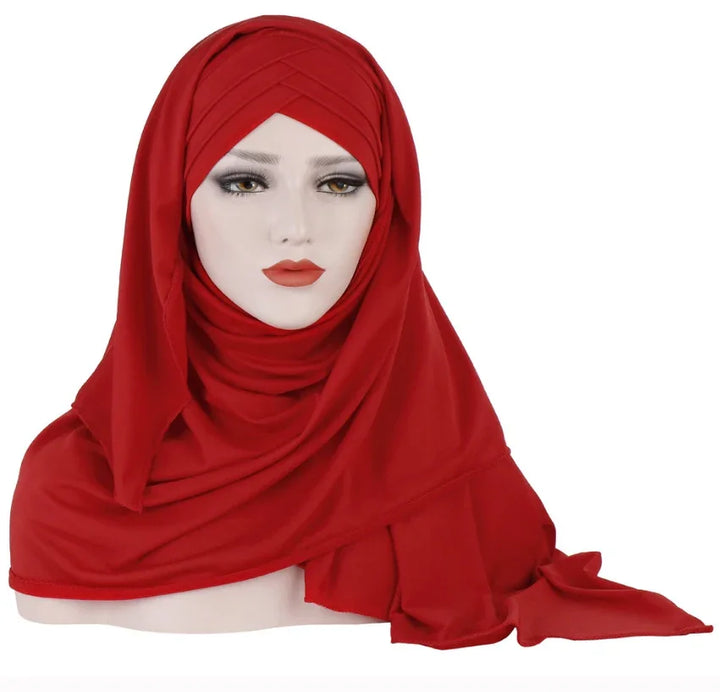 Mannequin head wearing a red hijab with layered folds over a white background