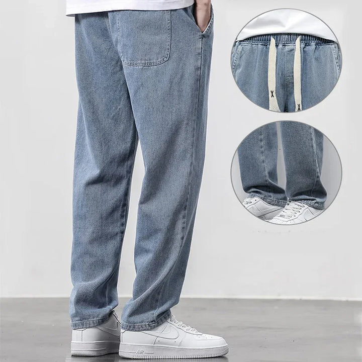 Light blue denim casual pants with elastic waistband and white drawstrings, worn with white sneakers