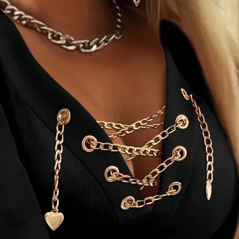 Close-up of black top with gold chain lacing and heart charm, styled with chunky chain necklace
