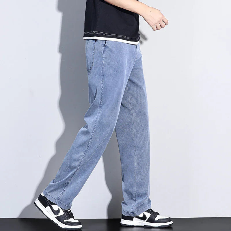Person wearing light blue casual pants and black white Nike sneakers walking against a plain background