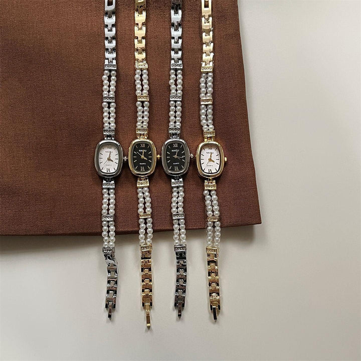 Set of four elegant quartz wristwatches with pearl and metal link bands on brown fabric
