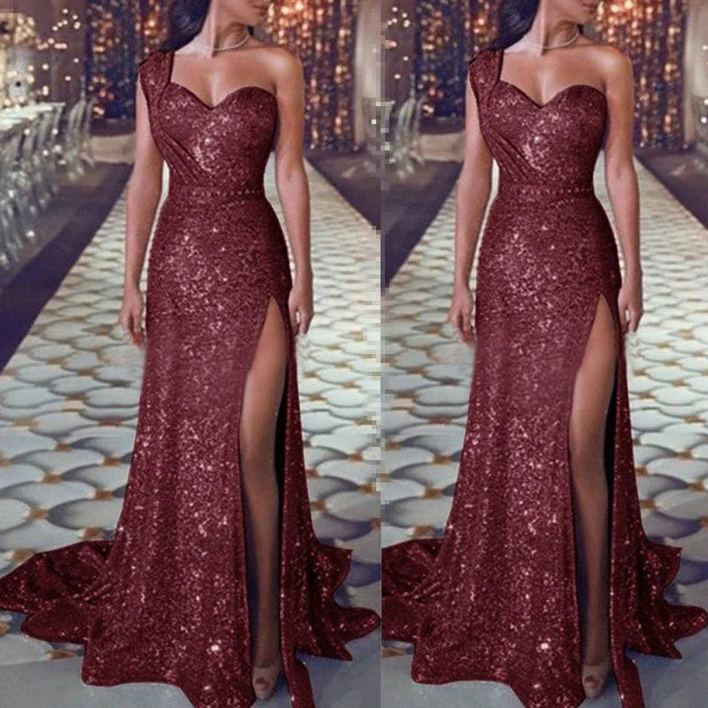 Woman wearing a sparkling burgundy one-shoulder evening gown with thigh-high slit on runway