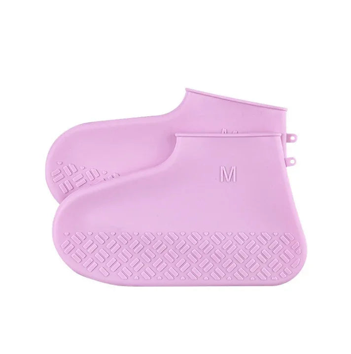 Pair of pink silicone shoe covers with textured soles and size M label, waterproof protective footwear