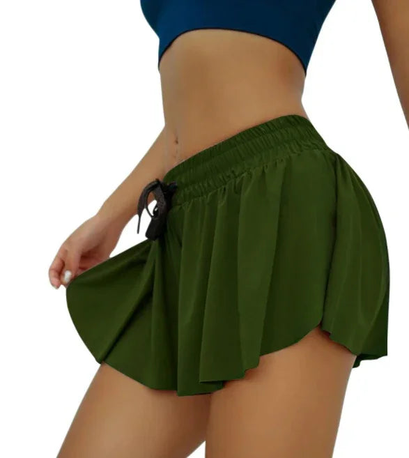 woman wearing olive green high-waisted athletic shorts with drawstring and navy crop top