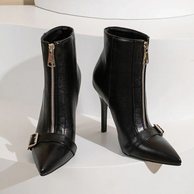 Pair of sleek black leather pointed-toe ankle boots with front zippers and decorative buckles