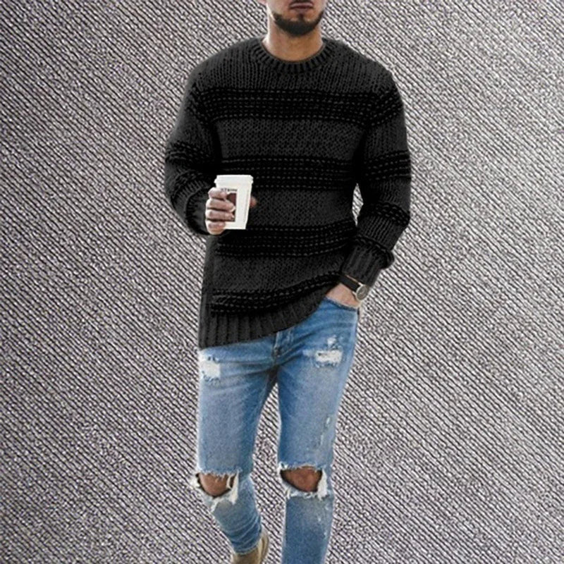 man wearing black knitted sweater and ripped skinny blue jeans holding coffee cup