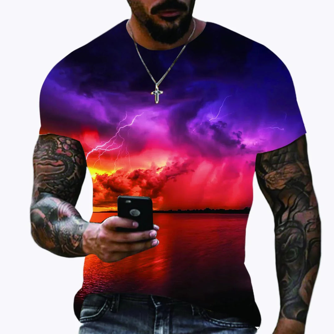 Man with tattooed arms wearing a colorful sunset storm graphic t-shirt holding a smartphone