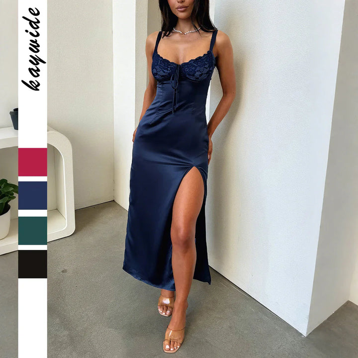 Woman wearing navy blue satin slip dress with lace bust detail and thigh-high slit indoors