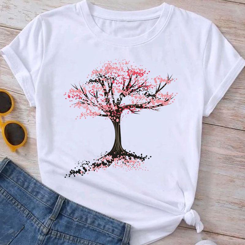 White t-shirt with artistic pink blossoming tree design paired with blue jeans and round yellow sunglasses