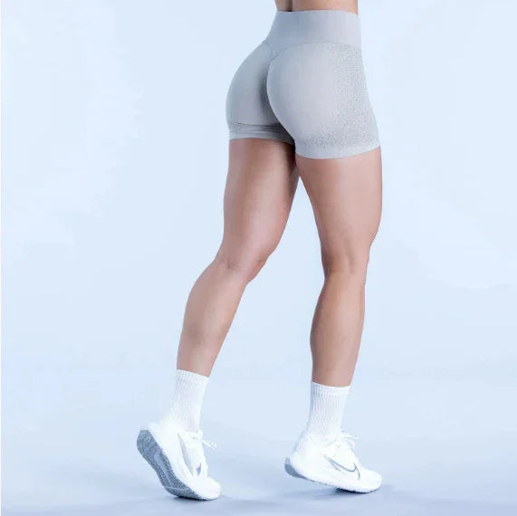 Woman in light gray seamless gym shorts, white sneakers, and socks, fitness apparel