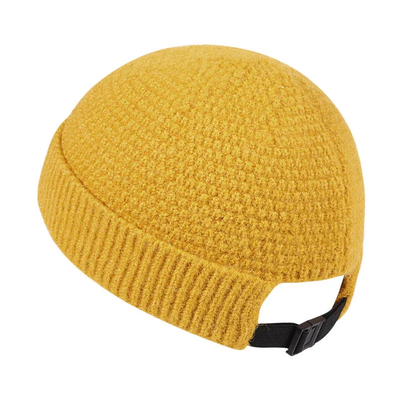 Mustard yellow knit beanie with adjustable black strap closure on white background