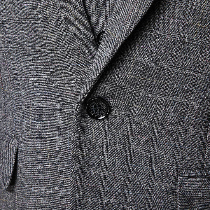 Close-up of gray plaid suit jacket with black button and textured fabric pattern