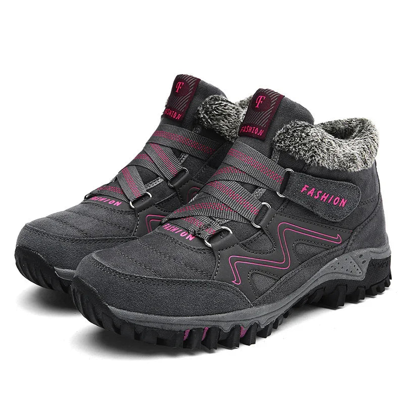 Gray winter hiking boots with pink accents, thick tread soles, and faux fur lining