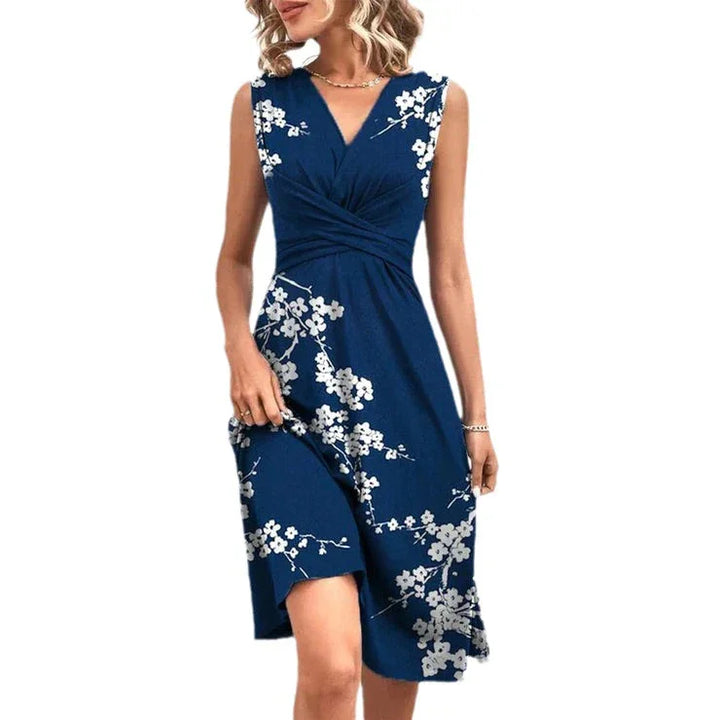 Woman wearing sleeveless navy blue floral midi dress with white blossoms and v-neck