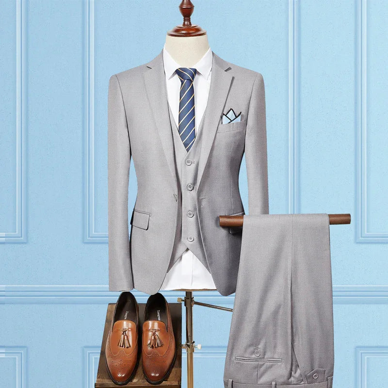 Light gray three-piece suit with blue striped tie and pocket square, paired with brown tassel loafers on mannequin