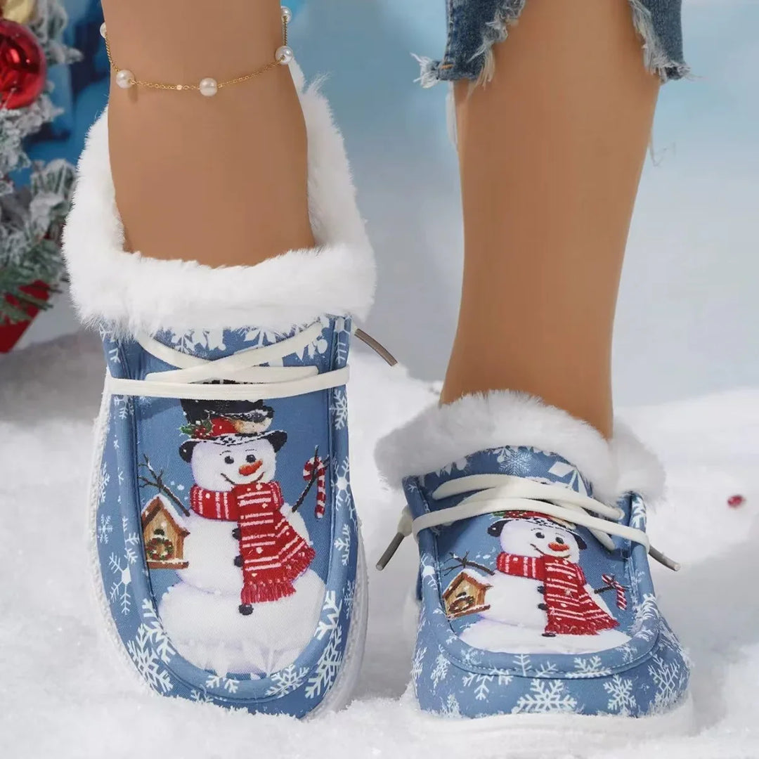 Blue winter slippers with white fur trim and snowman print worn with ankle bracelet and ripped jeans