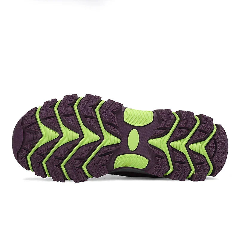 Close-up of purple and green rugged shoe sole with deep tread pattern for outdoor traction