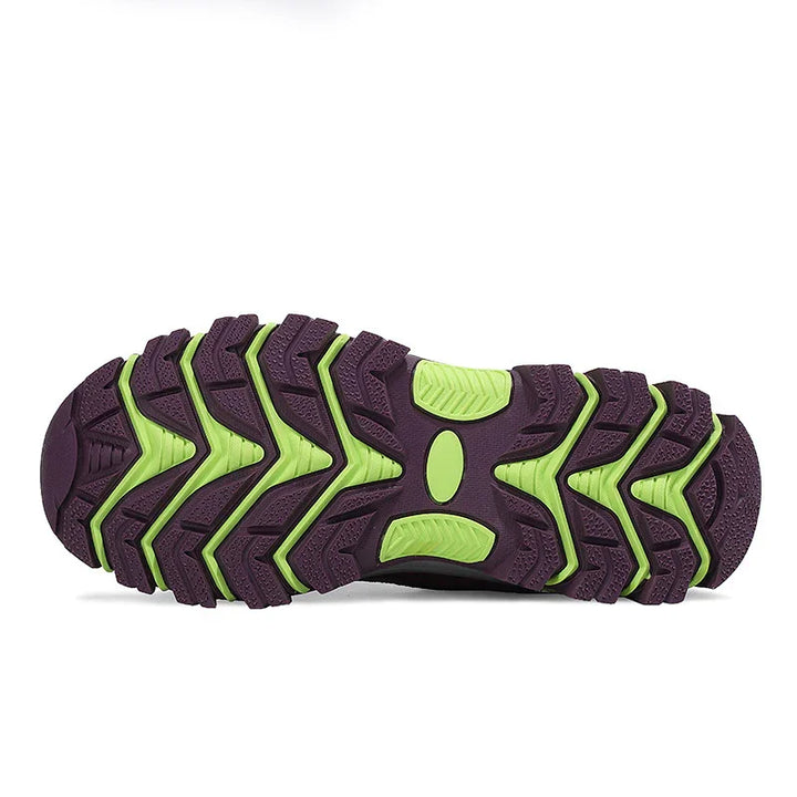 Close-up of purple and green rugged shoe sole with deep tread pattern for outdoor traction