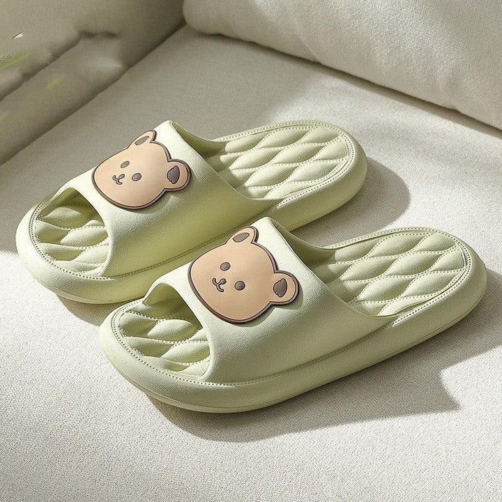 Light green cushioned slippers with quilted soles and cute bear face design on straps