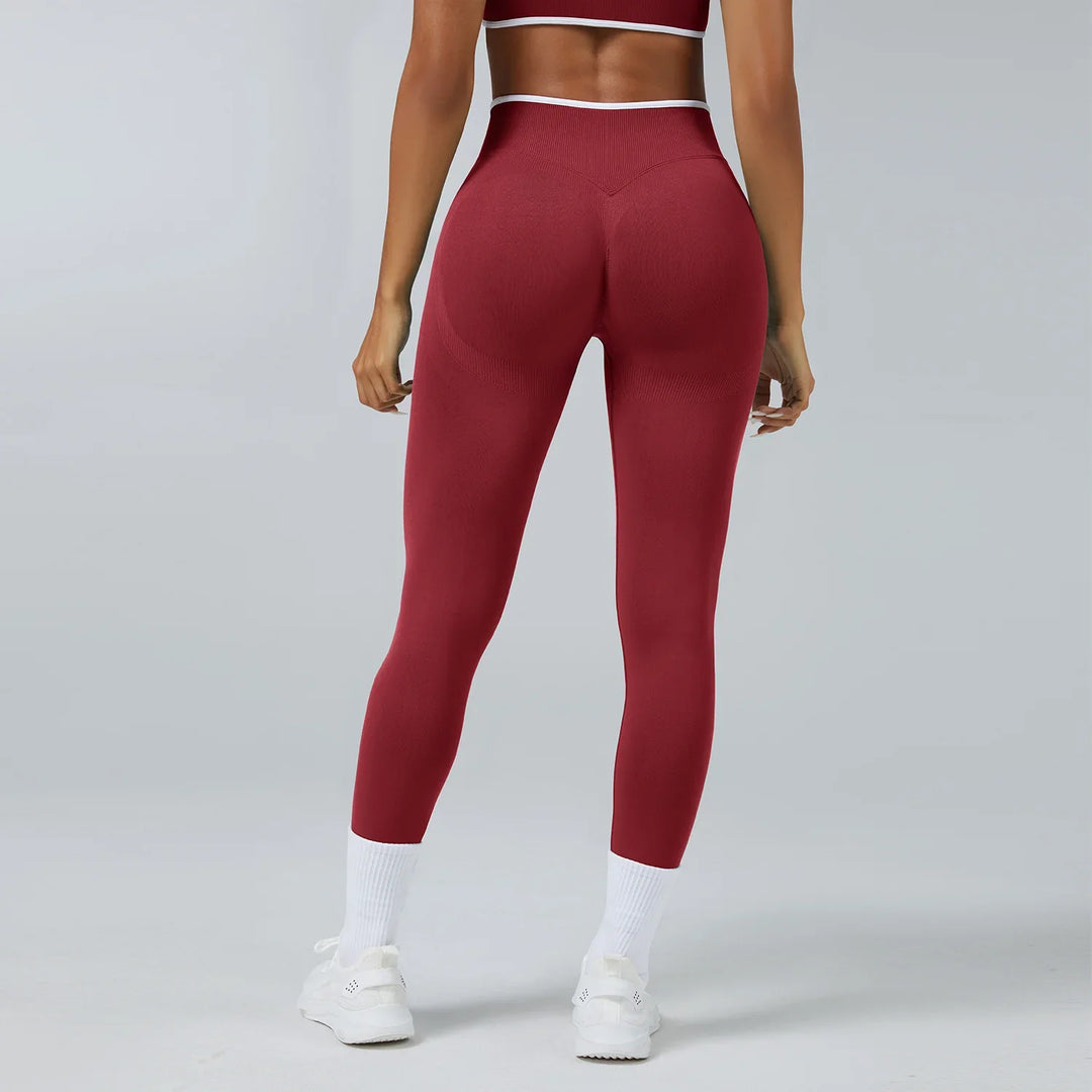 Rear view of woman wearing burgundy seamless leggings and matching sports bra with white sneakers