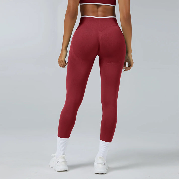 Rear view of woman wearing burgundy seamless leggings and matching sports bra with white sneakers