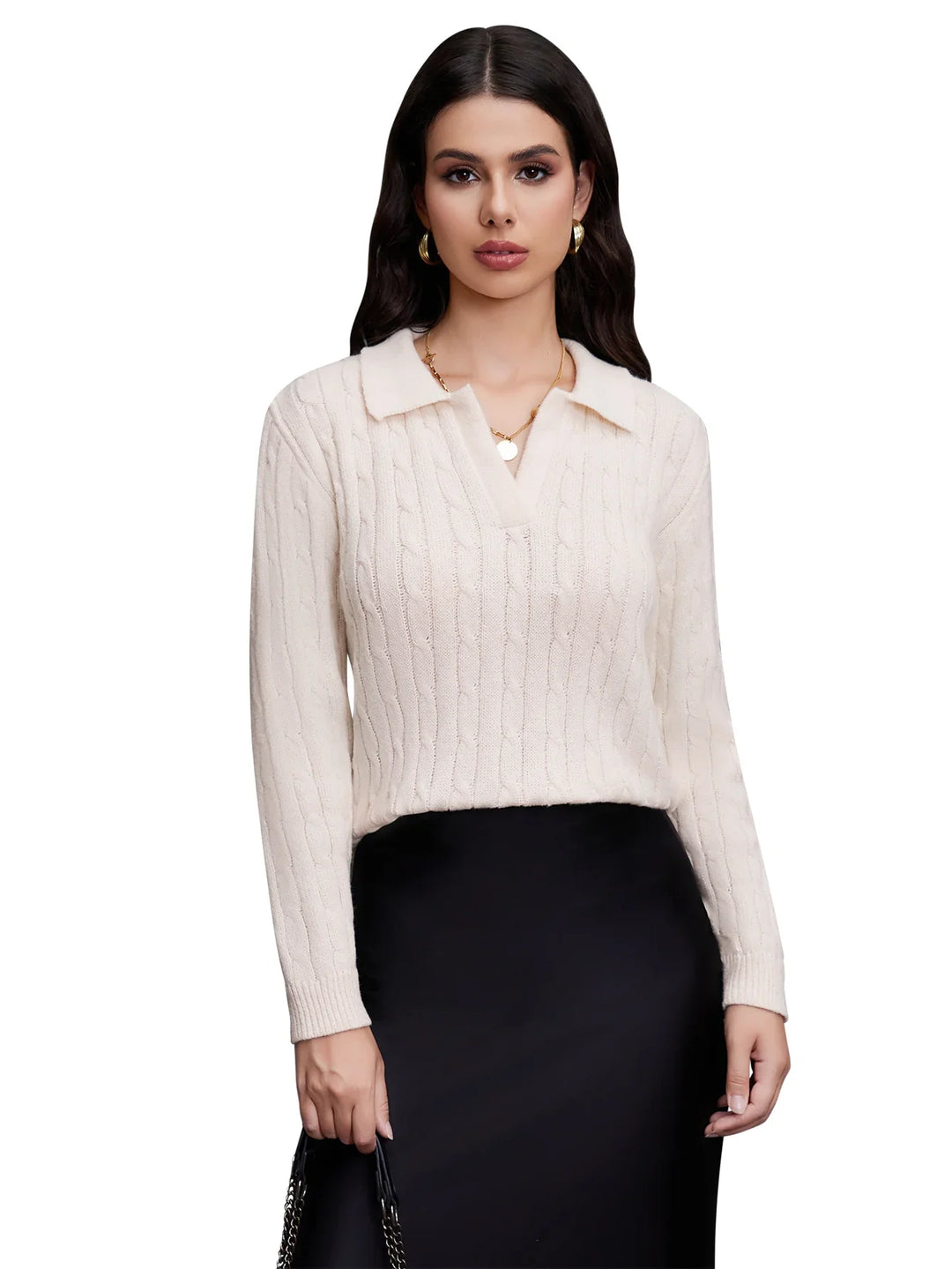 Woman wearing white cable knit sweater with collar and black skirt holding handbag