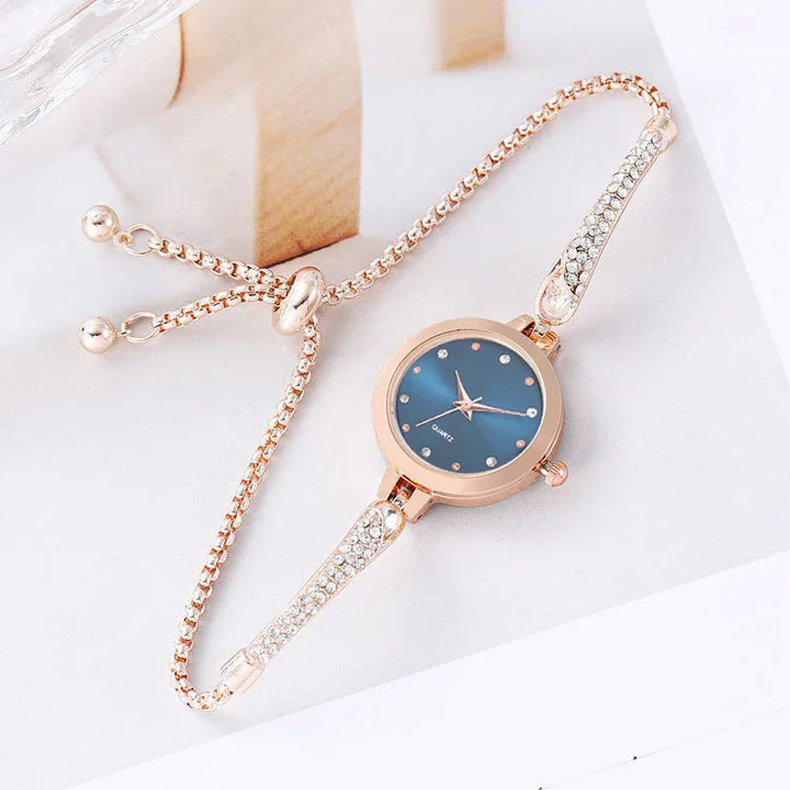 Elegant rose gold women's wristwatch with blue dial and crystal accents on bracelet