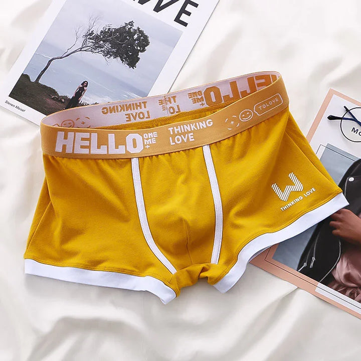 Yellow men's boxer briefs with white trim and waistband featuring text "HELLO THINKING LOVE" and smiley face design