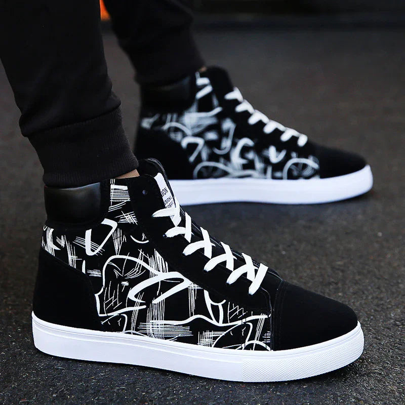 Black and white high-top sneakers with abstract white graffiti design and white laces on asphalt