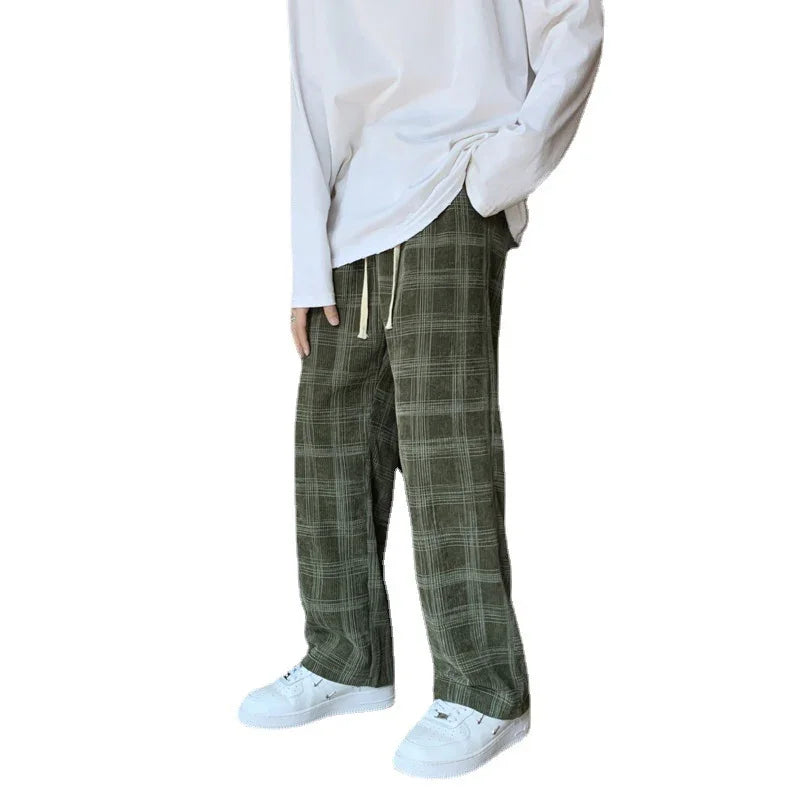 Person wearing loose green plaid pants with white drawstring and white sneakers