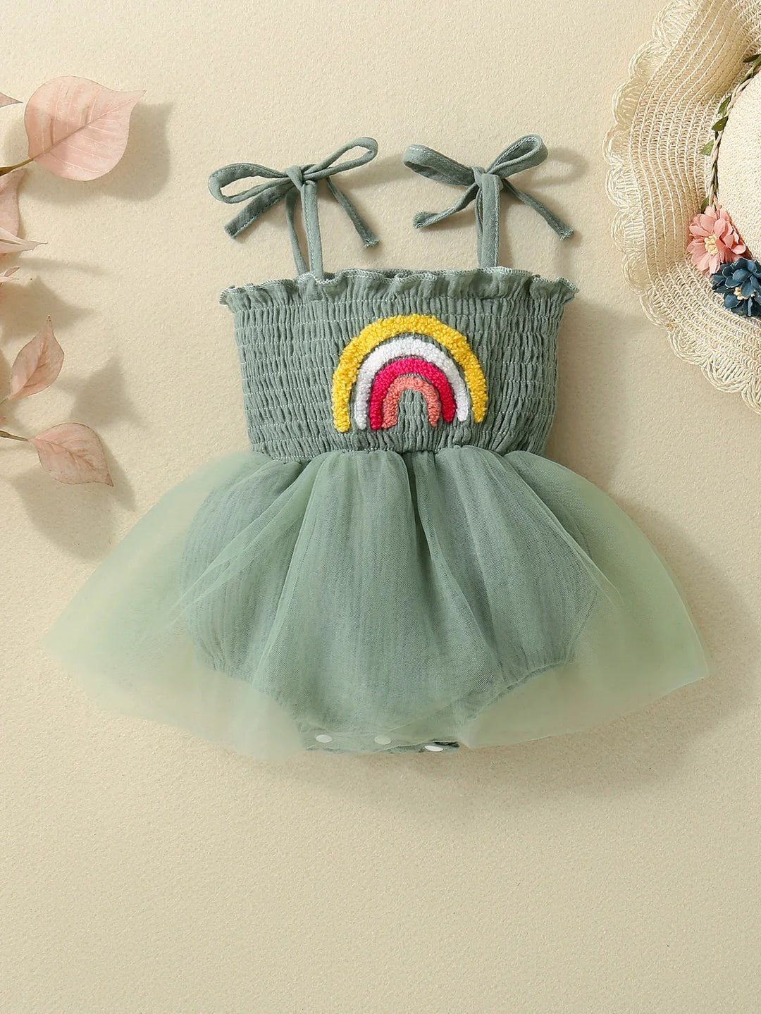 Green baby romper with smocked bodice, tulle skirt, rainbow appliqué, and bow shoulder straps