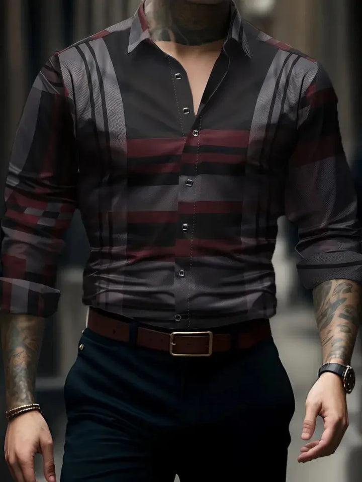 Man wearing stylish fitted dark patterned dress shirt with rolled-up sleeves and tattoos on arms