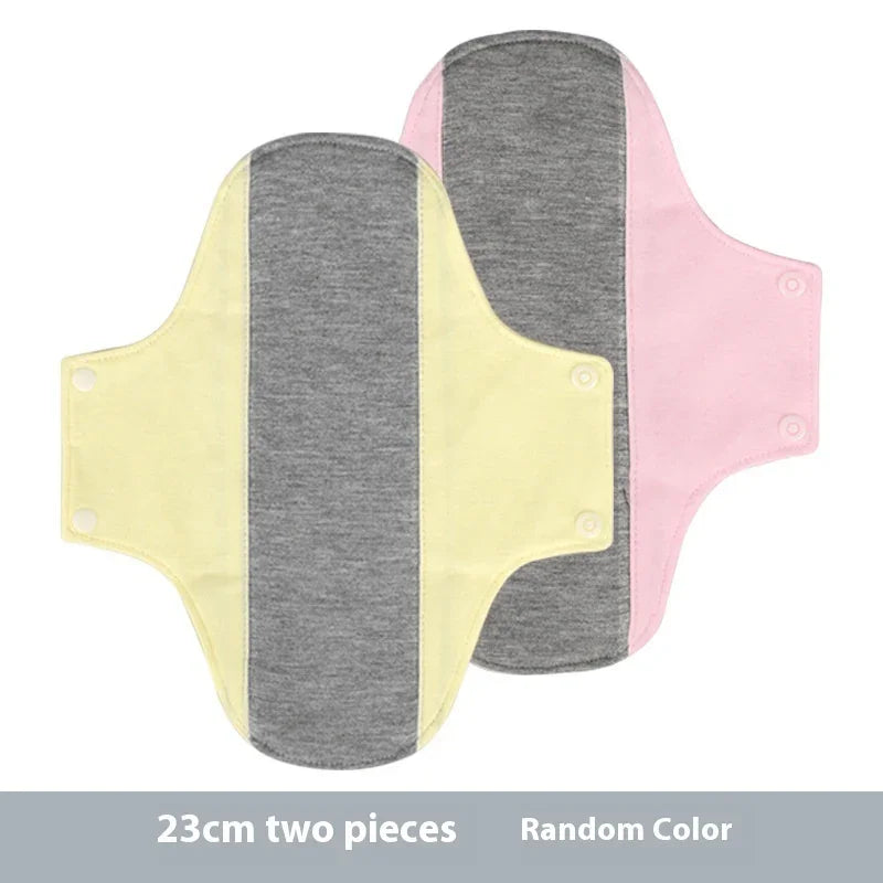 Two 23cm reusable cloth menstrual pads in pink and yellow with gray center, snap fasteners