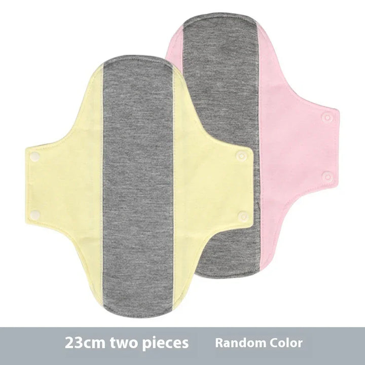 Two 23cm reusable cloth menstrual pads in pink and yellow with gray center, snap fasteners