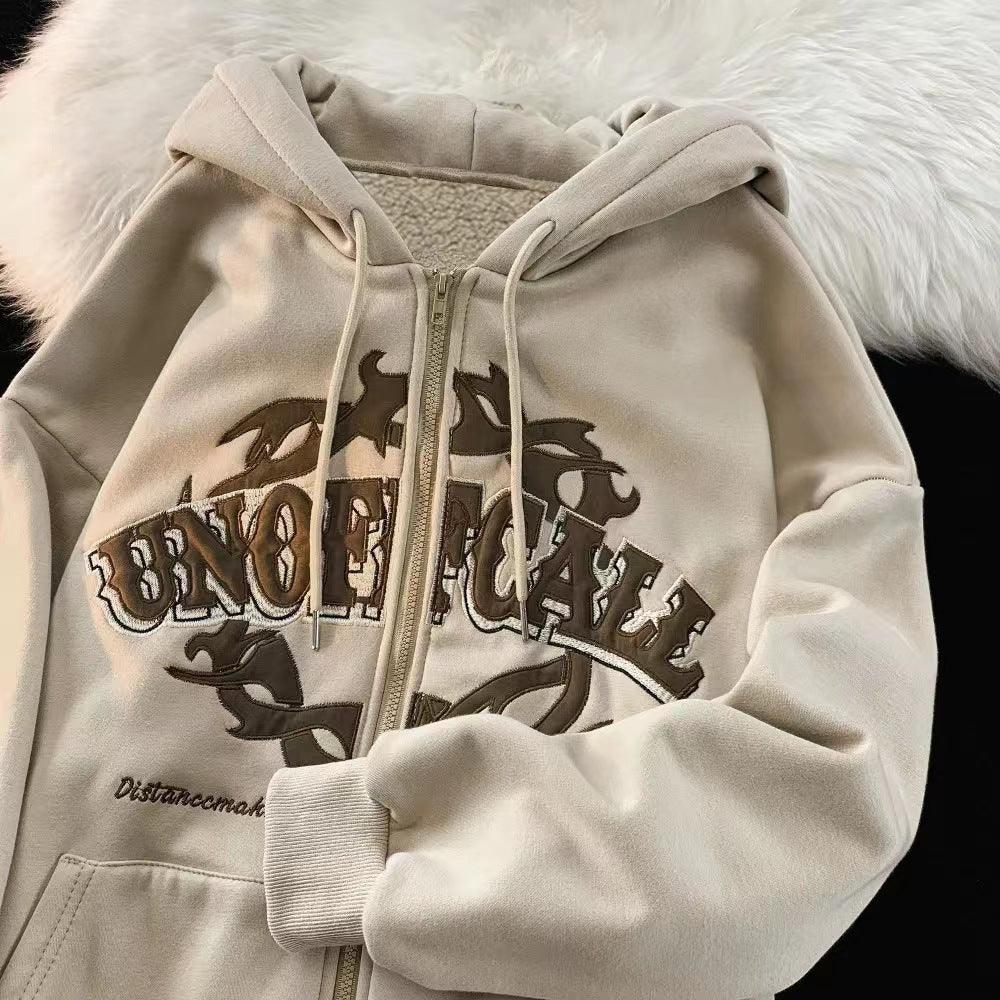 Beige zip-up hoodie with tribal design and text 'UNOFFICIAL' on a white fur background