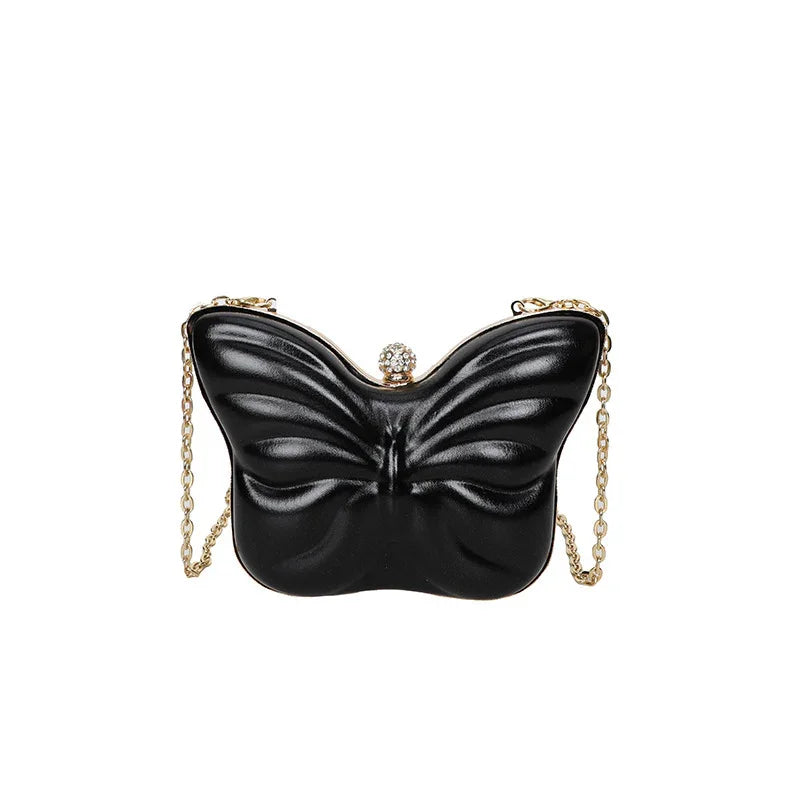 Black butterfly-shaped evening clutch bag with gold chain strap and rhinestone clasp