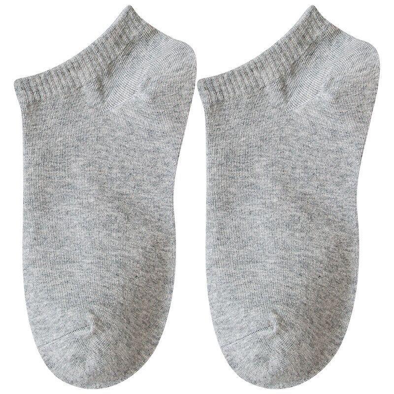 Pair of plain grey ankle socks made of soft knit fabric on white background