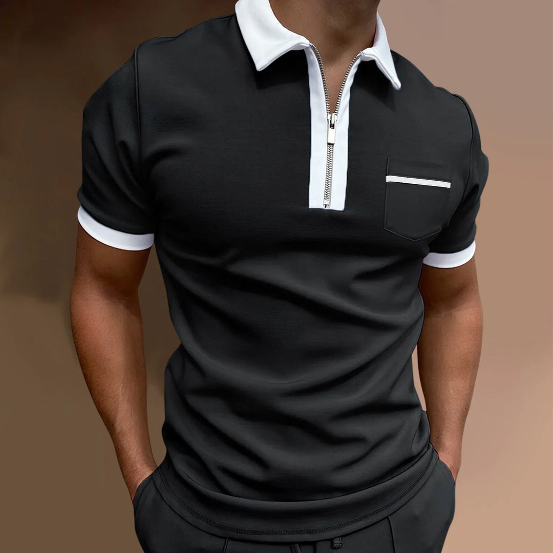 Man wearing black short-sleeve polo with white collar, white trim on sleeves, and front pocket detail