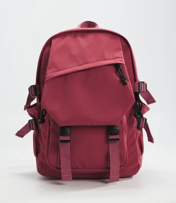 Dark red backpack with front zipper pocket, adjustable straps, and buckle closures on white background