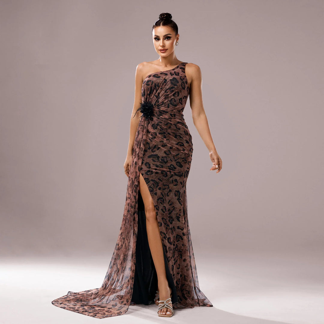 Woman in elegant one-shoulder leopard print evening gown with thigh-high slit and floral detail