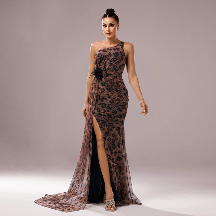 Woman in elegant one-shoulder leopard print evening gown with thigh-high slit and floral detail
