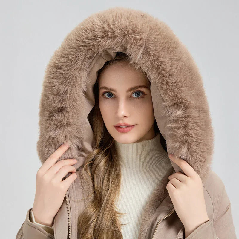 Woman wearing beige winter coat with large fur-lined hood and cream turtleneck sweater